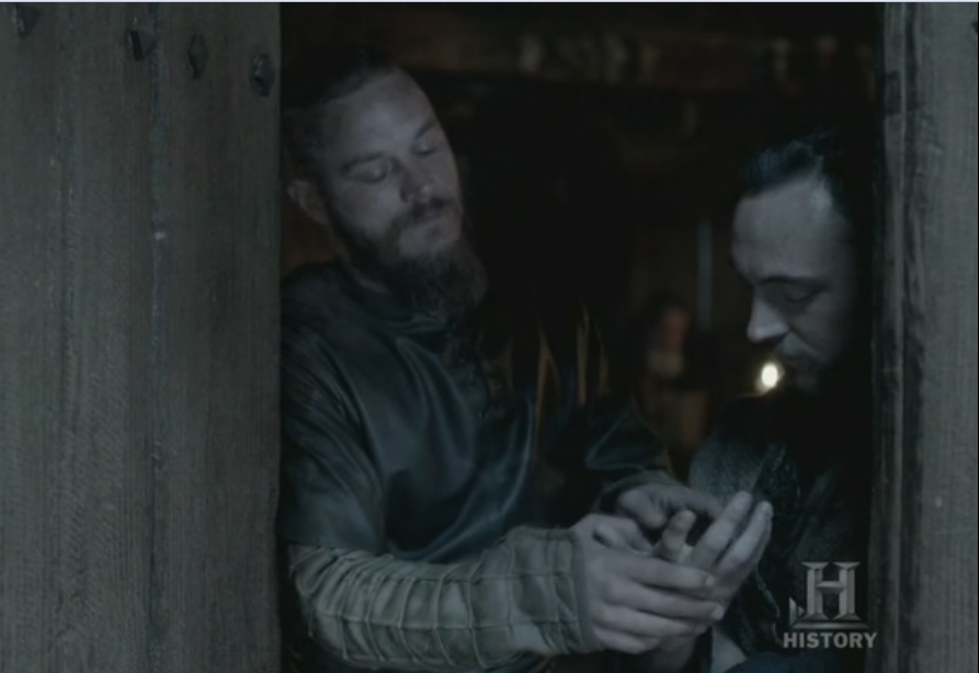 Ragnar mirándole las marcas de la crucifixión a Athelstan.